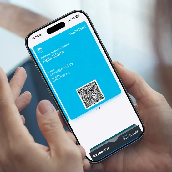 Digitale Visitenkarte fürs Smartphone-Wallet Eine Person hält ein Smartphone mit einer digitalen Visitenkarte mit Name, E-Mail-Adresse, Telefonnummer und einem QR-Code