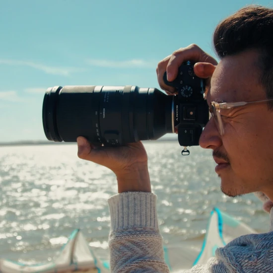 Serienerfolg für Nordsee-Tourismus-Service Foto eines jungen Mannes am Strand wie er mit einer Spiegelreflexkamera den Horizont fotografiert